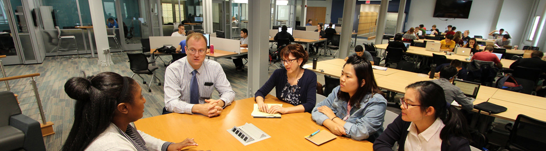 Faculty and staff sitting at a table in E-Knowledge Commons