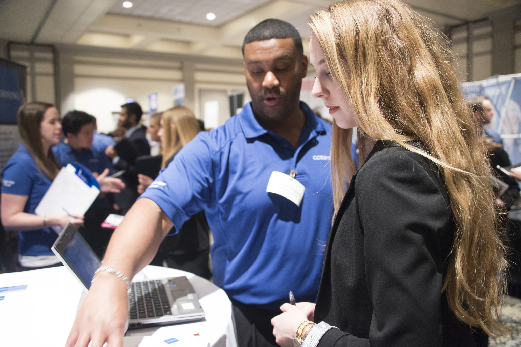 Student attends a career fair and discusses her resume with a recruiter.