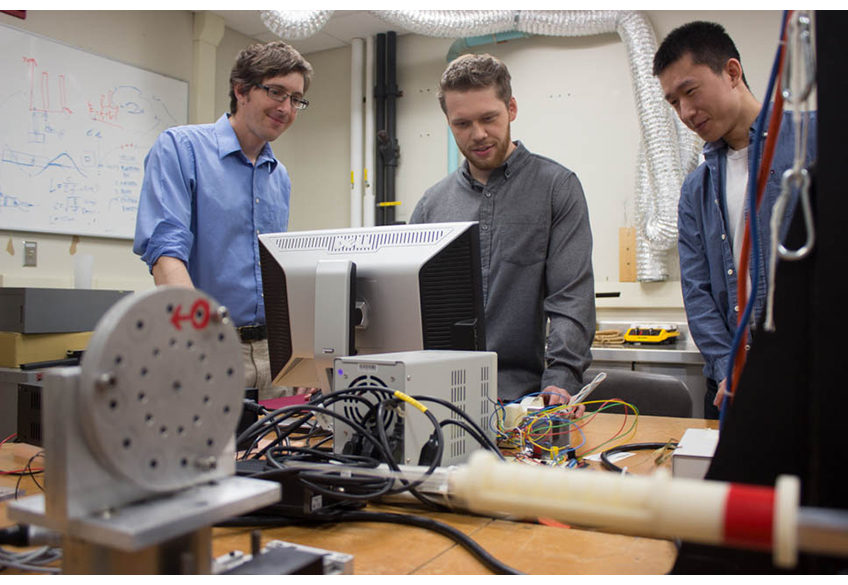 Jason Moore, associate professor of mechanical engineering, David Pepley, a doctoral student studying mechanical engineering, and Yichun (Leo) Tang, undergraduate student studying mechanical engineering work with the needle simulator training device.