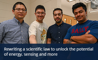 Four people pose for a photo with the second person holding a sample on a sample box